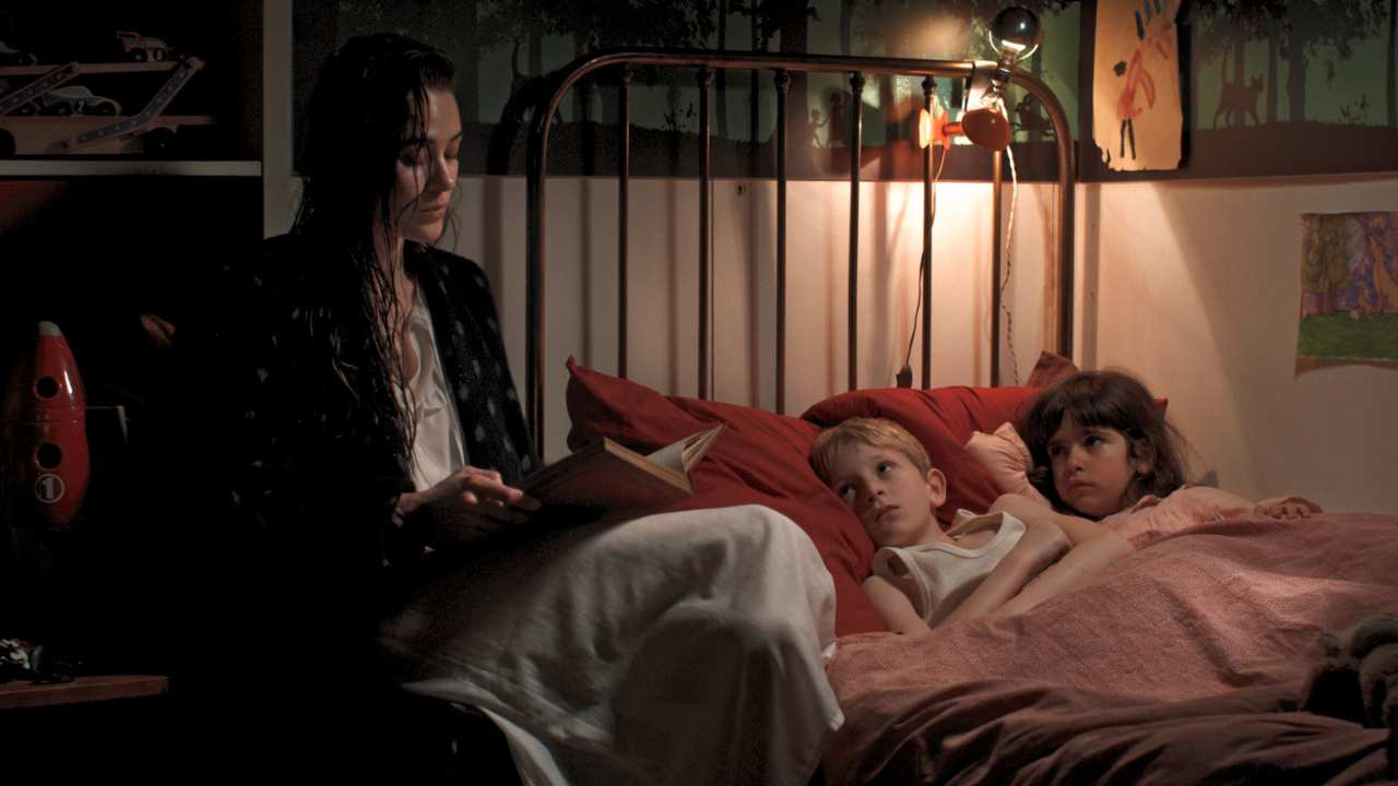 a woman reading a bedtime story to two children